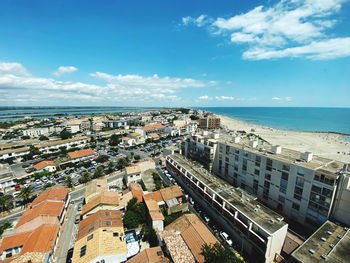 High angle view of buildings and sea against sky