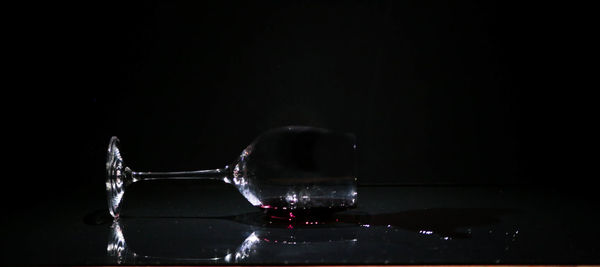 Close-up of glass over water against black background