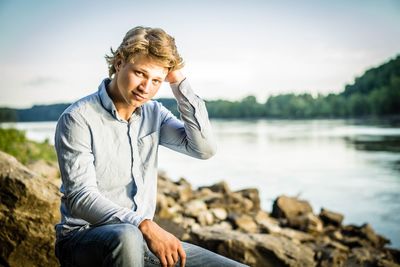 Portrait of man sitting at lake