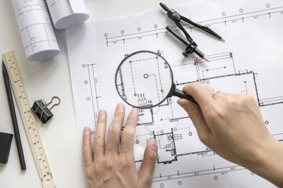 Cropped hand of person holding magnifying glass