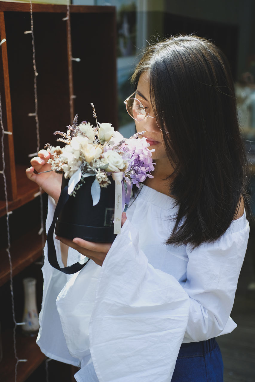 WOMAN HOLDING WHITE FLOWER