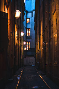 Narrow street amidst buildings at night
