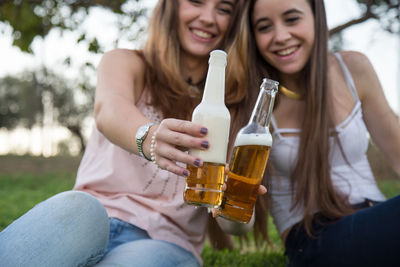 Happy friends toasting beer bottles