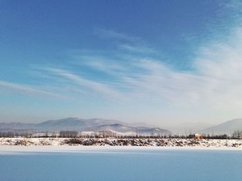 Scenic view of snow covered landscape against blue sky