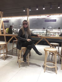 Portrait of woman sitting on chair in restaurant