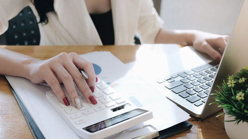 Midsection of man using laptop on table