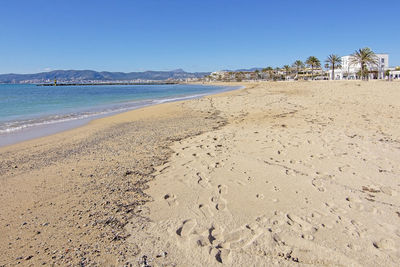 Scenic view of beach against clear blue sky