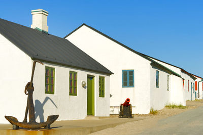 Rear view of man walking on footpath against building