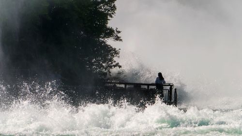 Man surfing in sea against sky