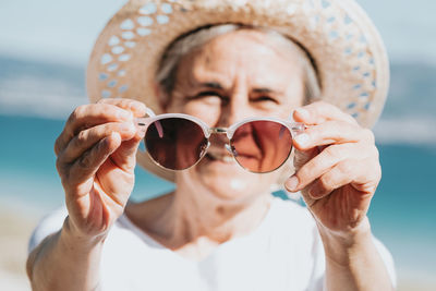 Close-up of woman wearing sunglasses against white background