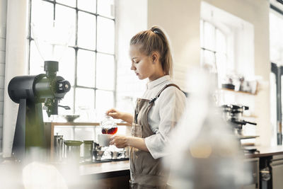 Barista making coffee at cafe counter