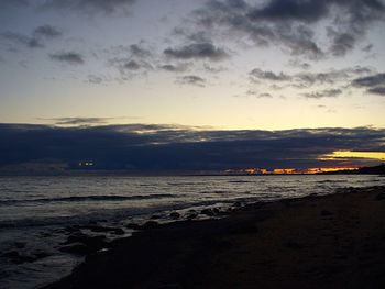 Scenic view of beach against cloudy sky