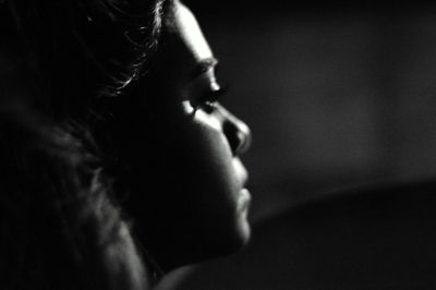 Close-up of woman looking away against wall