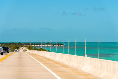 Road by sea against blue sky