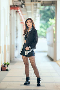 Portrait of fashionable woman standing in corridor