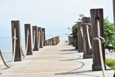 Wooden posts on beach against clear sky