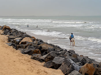 People on beach against sky