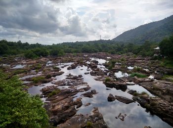 Scenic view of river and mountains against sky