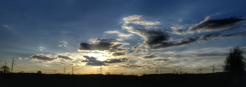 Silhouette of field against sky at sunset