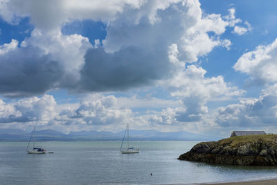 Two sailboats at anchor off ynys llanddwyn on anglesey, north wales