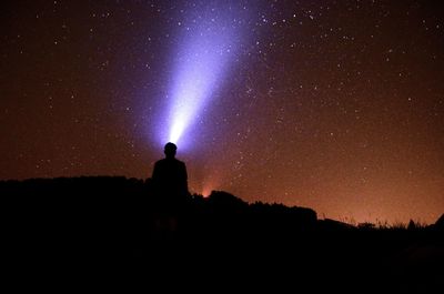 Silhouette man against sky at night