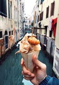 Woman holding ice cream cone on street