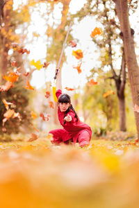 Side view of woman sitting on swing in park