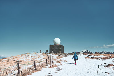 Rear view of person on snowcapped mountain against sky