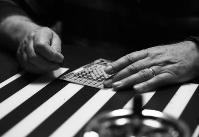 Close-up of man scratching lottery ticket