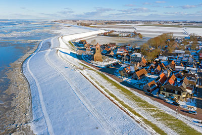 Aerial from snowy village wierum in friesland at a frozen waddensea in the netherlands in winter