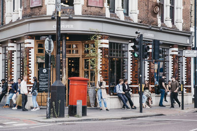 People walking on street against buildings in city