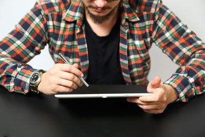 Midsection of man using digital tablet