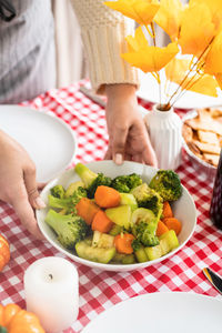 Cropped hand of woman holding food on table