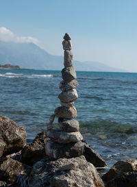 Stack of rocks on beach against sky