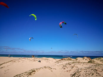 Scenic view of beach against blue sky