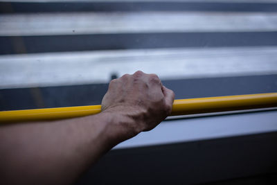 Cropped hand of person holding railing