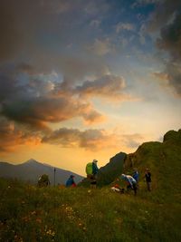 People on field against sky during sunset