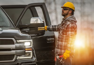 Side view of worker holding car door