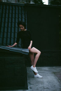 Beautiful young woman sitting on roof