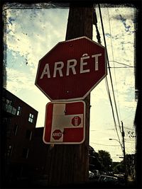 Road sign against cloudy sky