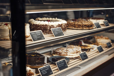 Varieties of cakes arranged on retail display at cafe