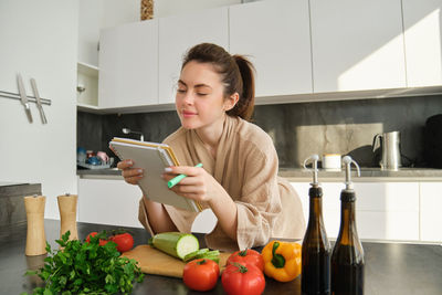 Portrait of young woman using mobile phone at home