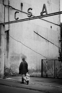 Rear view of man walking on road