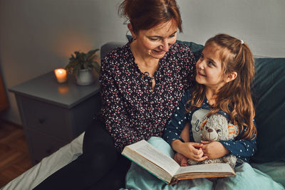 Young woman sitting on book