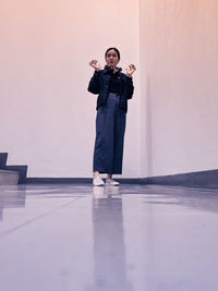 An asian office worker standing at the fire exit area showing off her face mask