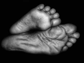 Close-up of baby hand against black background