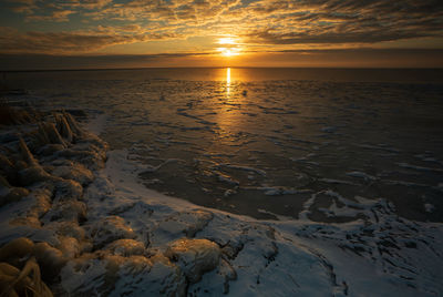 Scenic view of frozen sea against sky during sunrise