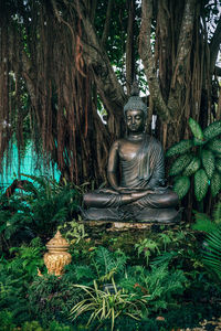 Statue amidst trees against plants