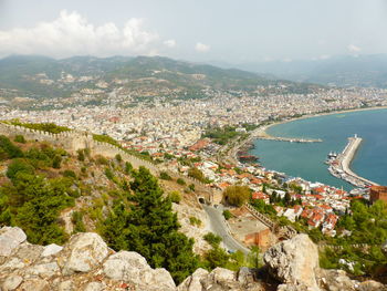 High angle view of townscape by sea against sky