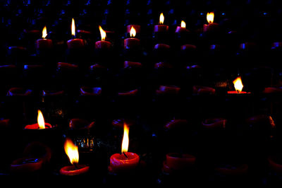 Close-up of lit candle in dark room